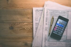 calcolatrice e busta paga su tavolo legno