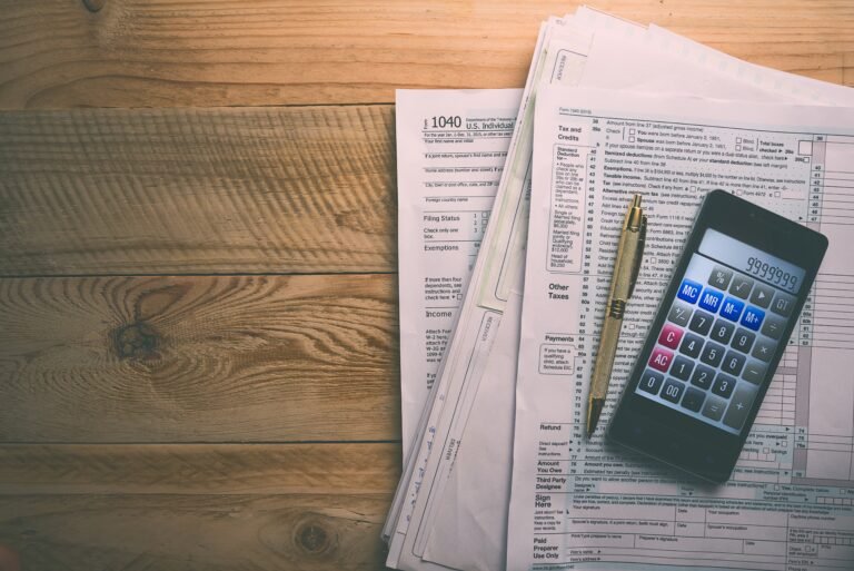 calcolatrice e busta paga su tavolo legno