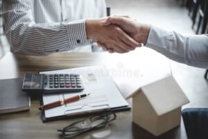 due mani che firmano insieme un documento bancario