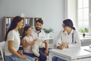 Quali Vantaggi Offre un'Assicurazione Sanitaria Privata per Famiglie 34 famiglia felice che consulta un medico in clinica