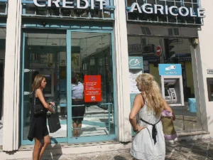filiale credit agricole con clienti sorridenti fuori