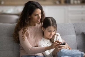 Quali Sono Le Migliori App Per Genitori Single Per Gestire La Vita Quotidiana 13 genitore single che usa smartphone con bambino