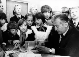 gianni rodari che scrive con bambini sorridenti