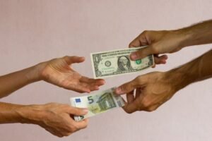 mani che scambiano banconote e cambiali