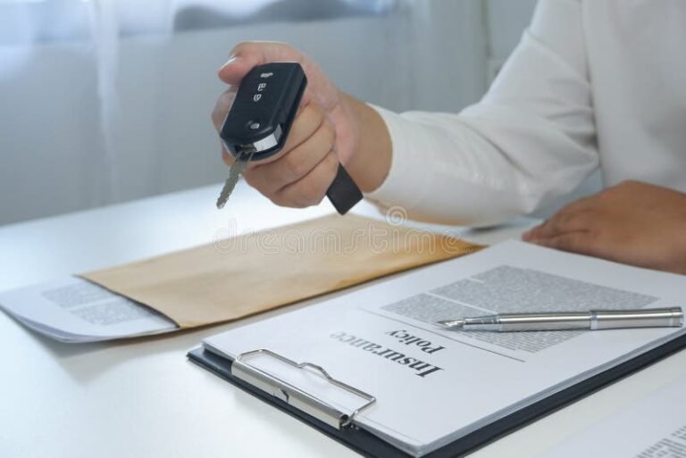 mano che firma contratto assicurativo con chiavi