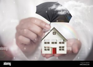 mano che protegge una casa con ombrello