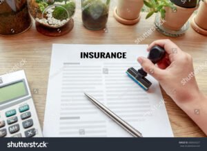 mano che tiene una calcolatrice e un documento assicurativo