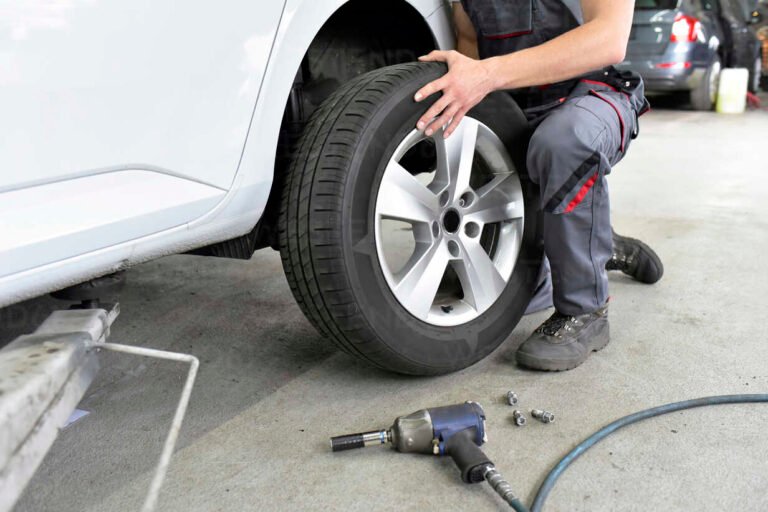 meccanico che cambia pneumatici auto in officina