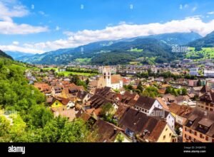 panorama urbano con case e montagne verdi