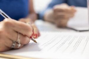 persona anziana che firma documento finanziario