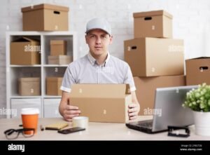 persona con laptop e pacchi spedizione