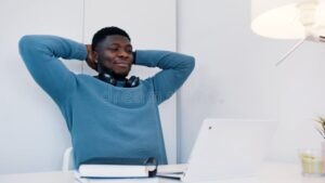 persona sorridente con cuffie davanti a laptop