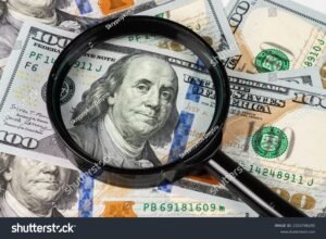 Come Capire Se I Soldi Sono Falsi: Quali Sono I Segnali Da Controllare 15 primo piano di una banconota sotto lente dingrandimento