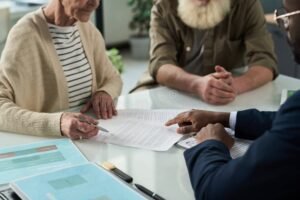 un pensionato che firma documenti finanziari