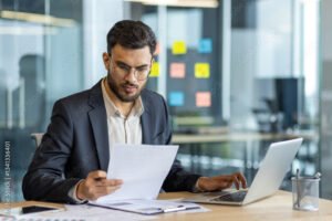 uomo pensieroso con documenti finanziari in mano